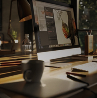 A designer's workspace, dark and warm, with physical materials visible
